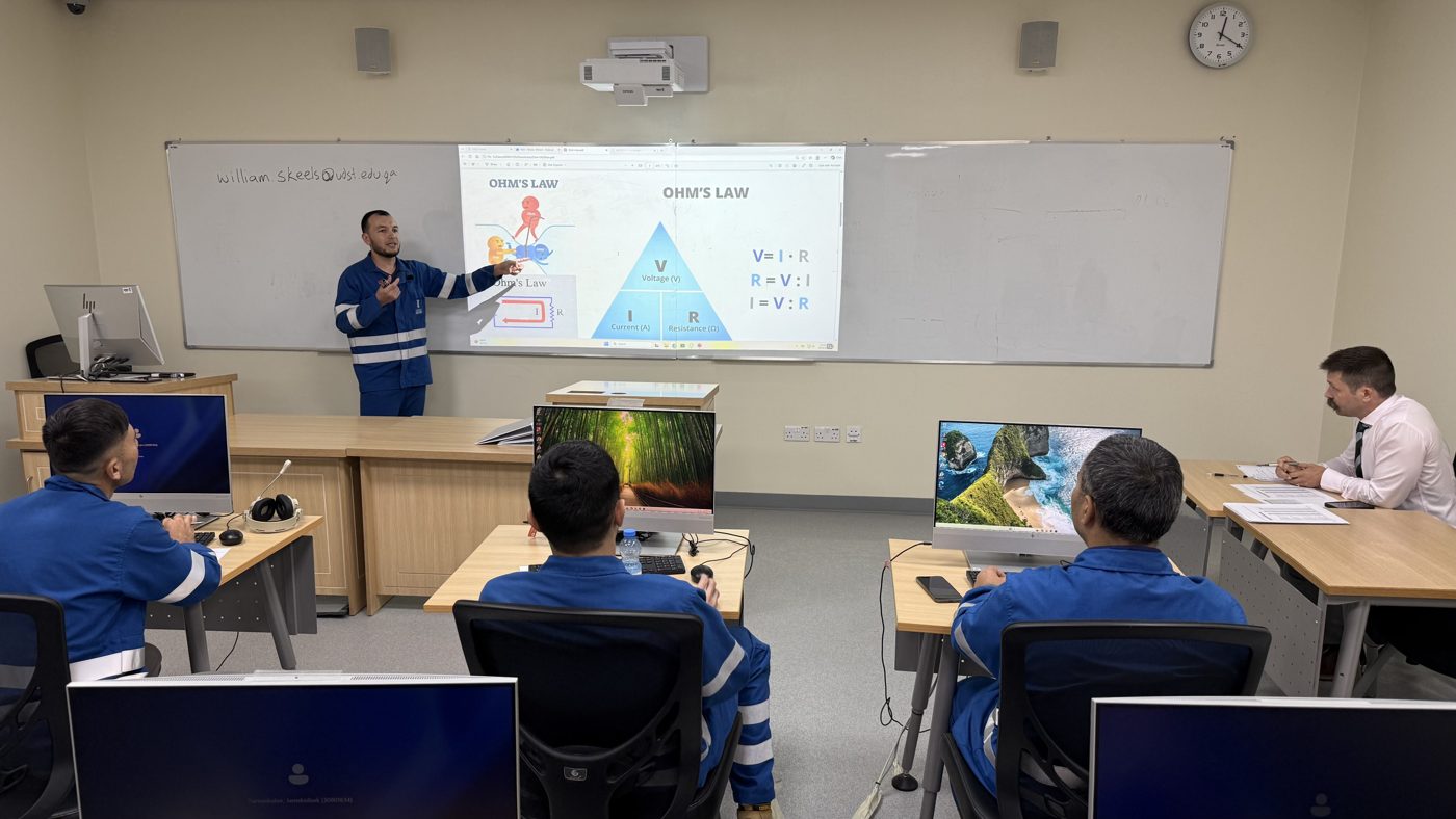 Instruktor sinfda Om qonuni bo‘yicha ingliz tilida taqdimot qilmoqda